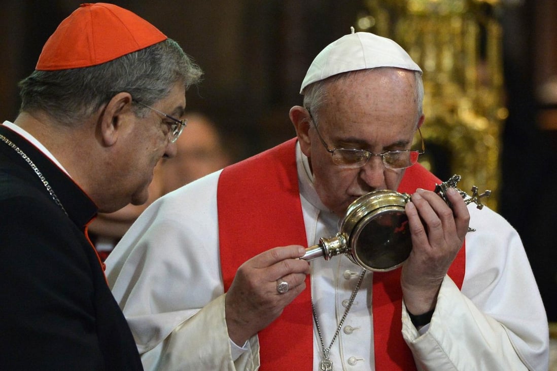 Pope Francis (right) kisses the ampulla containing the blood of Saint Januarius, patron of Naples, during his visit to the Duomo. Photo: AFP