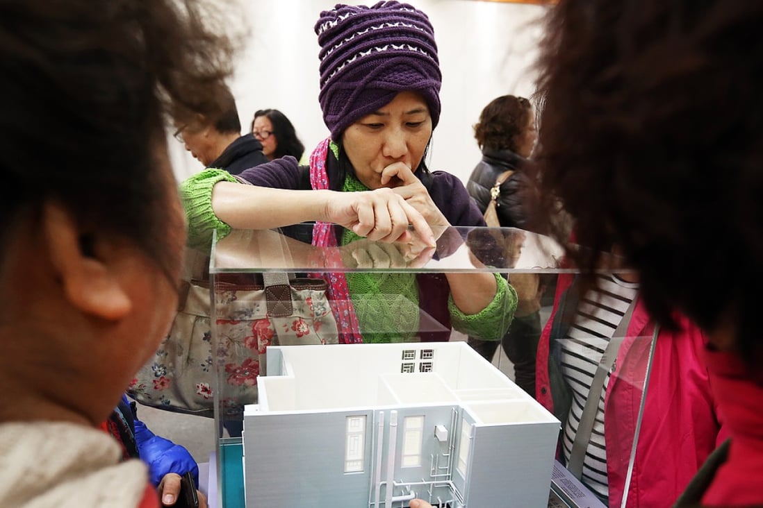 People watch the models of new HOS flats during the first day's application at Hong Kong Housing Authority Customer Service Centre in Lok Fu in December, 2014. Photo: Nora Tam