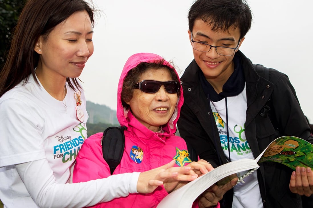 Two young volunteers assist a visually impaired woman during a special bird-watching tour at the Inspiration Lake. The Shue Yan University study of people aged 15 to 24 found that those who were in employment and who had done voluntary work, housework and were regular savers generally scored higher level of competitiveness than their peers. Photo: SCMP