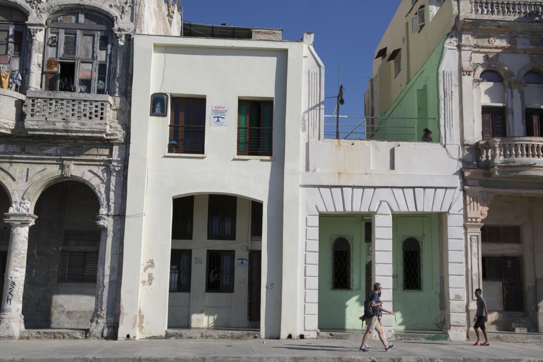 Tourists walk past houses with rooms for rent in Havana. Airbnb now allows licensed American travellers to book lodgings in Cuba. Photo: AP