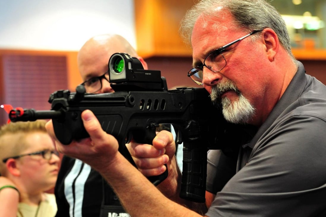 A man aims a gun during the NRA convention. Photo: AFP