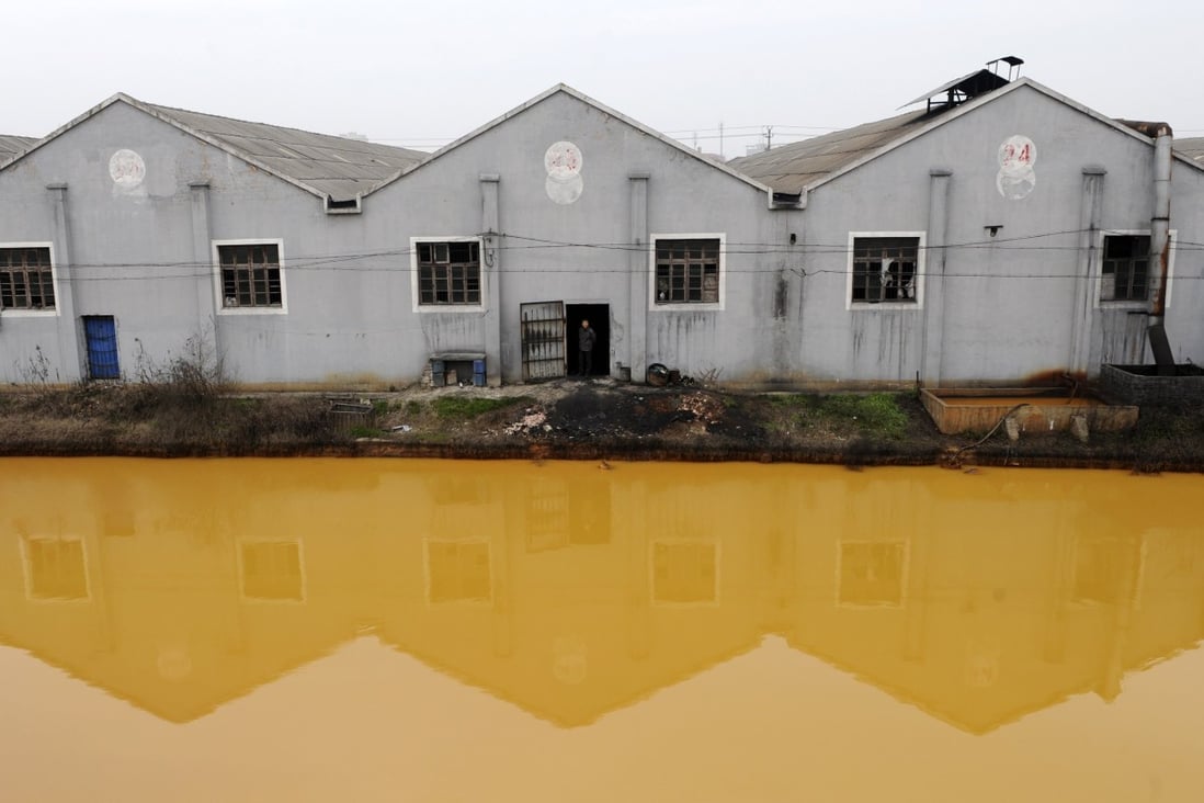 A polluted river runs past a factory in Jiaxing, Zhejiang province. The mainland is banning water-polluting plants. Photo: Reuters