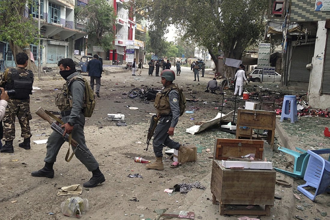 Afghan security forces members inspect the site of a suicide attack near a new Kabul Bank in Jalalabad. Photo: AP