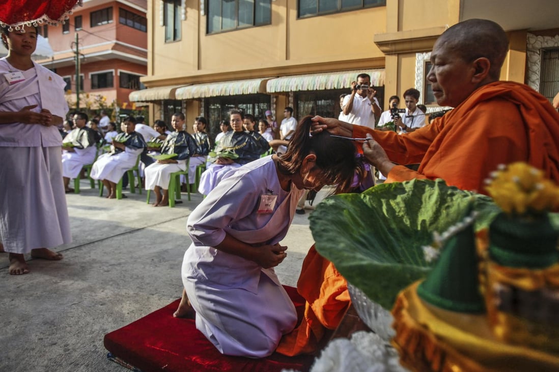 Venerable Dhammananda cuts the hair of a samaneri, or novice in the clergy, at the Songdhammakalyani temple, outside Bangkok.
