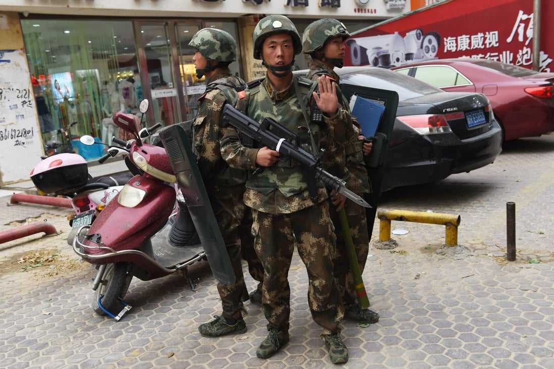 Paramilitary police officers on guard by a shopping centre in Hotan in Xinjiang. Photo: AFP
