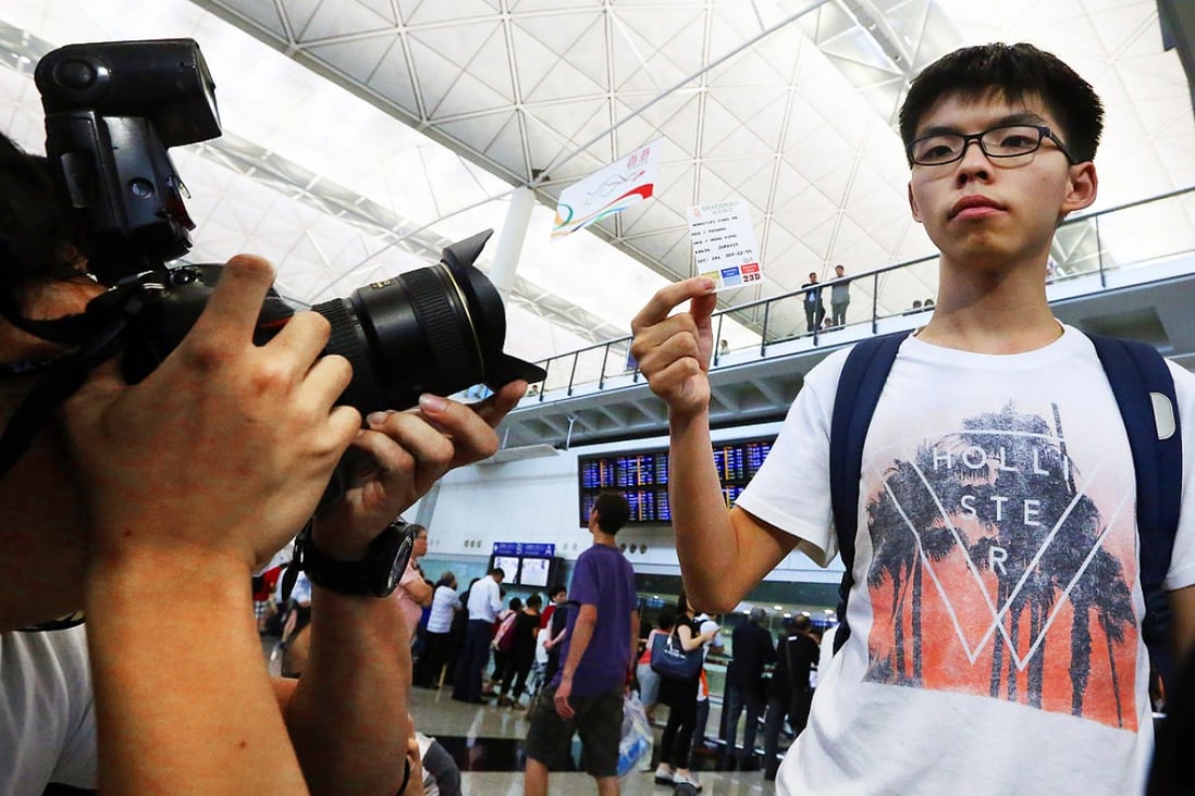 Joshua Wong displays his boarding pass at Hong Kong International Airport after Malaysian authorities refused him entry and ordered him to return. Photo: Sam Tsang