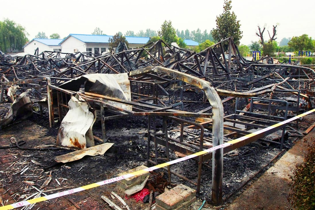 Police and inspectors examine the scene of the blaze in Henan province. Photo: EPA