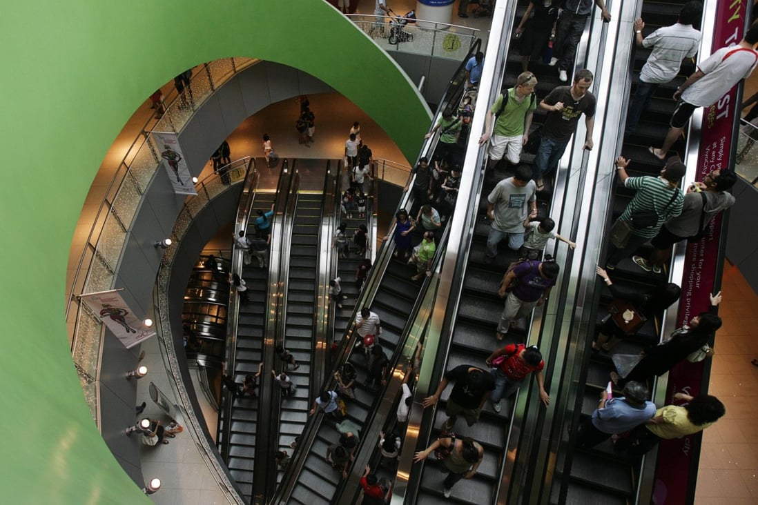 Shoppers ride the escalators at VivoCity shopping mall in Singapore. VivoCity is Mapletree's retail brand, which is also established in other cities in China, as well as  in Vietnam. Photo: Reuters