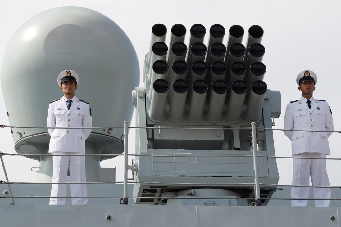 Officers from the People's Liberation Army Navy stand at attention on board a naval guided missile destroyer. File Picture