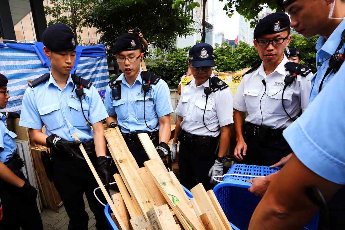 Police officers remove items deemed to be a risk to public safety outside government headquarters yesterday. Photos: Sam Tsang