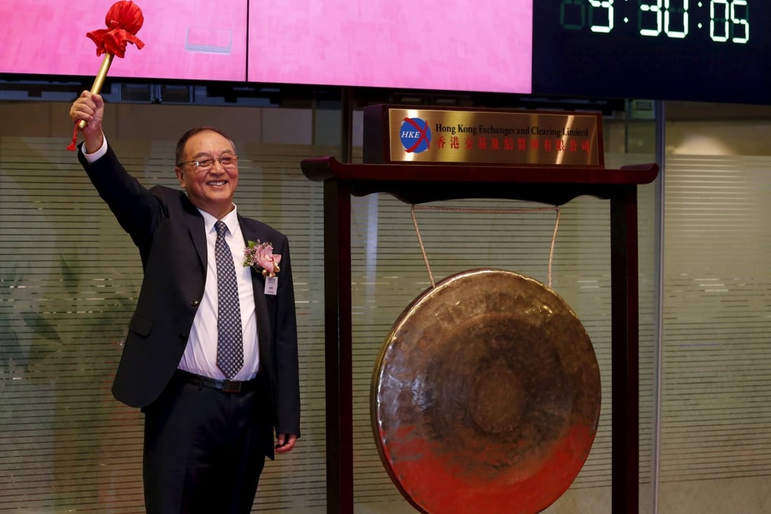 Liu Chuanzhi, chairman of Legend Holdings, hits the gong during the debut of the company on the Hong Kong stock exchange. Photo: Reuters