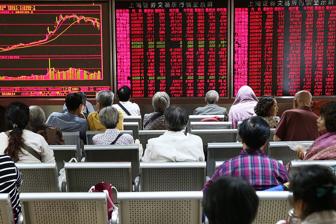 Investors watch stock prices at a brokerage house in Beijing. China’s two major stock exchanges will lower securities transaction fees in the wake of a recent market slump. Photo: EPA