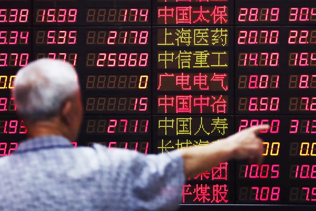 An investor looks at information displayed on an electronic screen at a brokerage house in Shanghai. Photo: Reuters