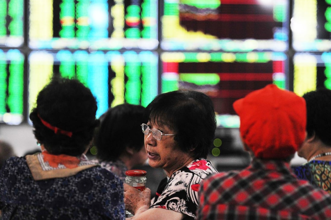 Investors in Wuhan in central China anxiously monitor share prices at a securities firm. Photo: AFP
