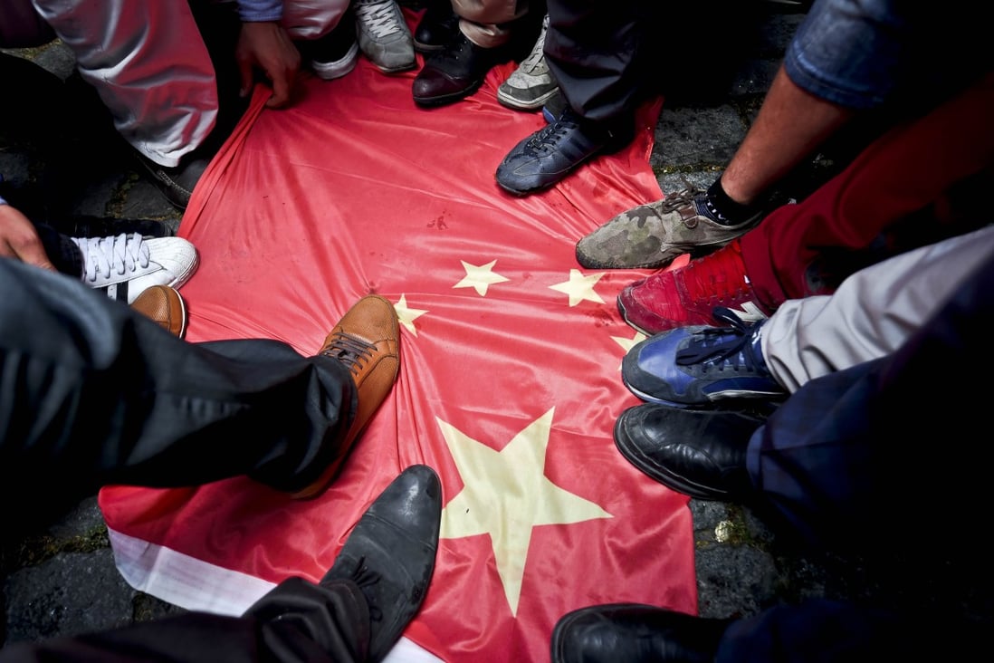 Protesters step on a Chinese flag during a protest to denounce China's treatment of ethnic Uighur Muslims, in front of the Chinese consulate in Istanbul. Photo: AFP