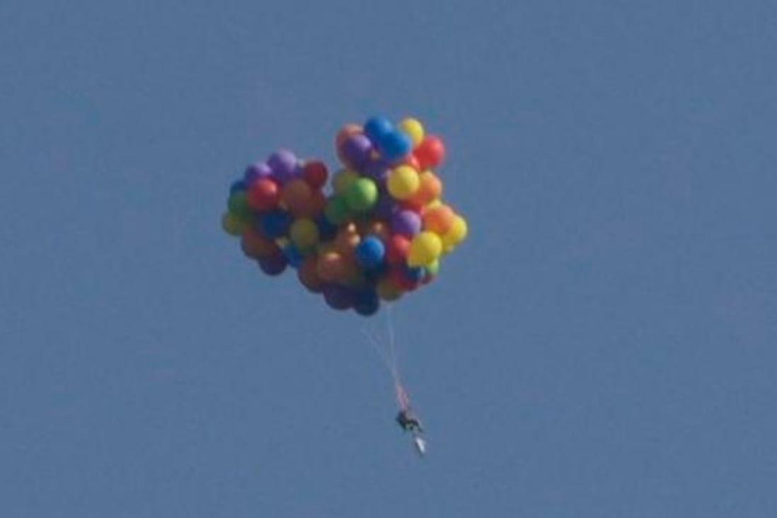 Up up and away... One brave Canadian takes to the sky in a balloon powered chair. Photo: SCMP Pictures