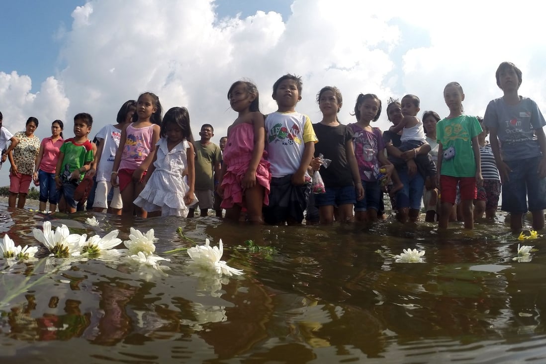 Survivors of Typhoon Haiyan put flowers into the sea as they commemorated the first anniversary of the disaster last year. Photo: Xinhua