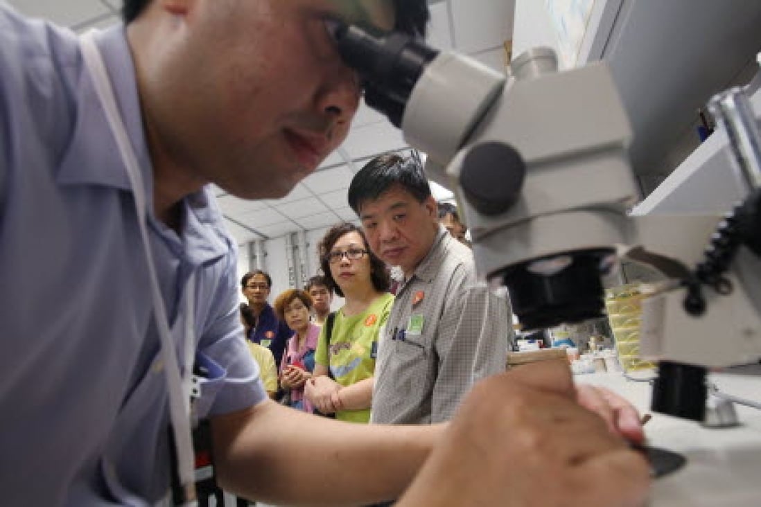 A dad looks through an electron microscope on Parents' Day at the X-Ray and Crystallography Laboratory at HKUST. Photo: Felix Wong