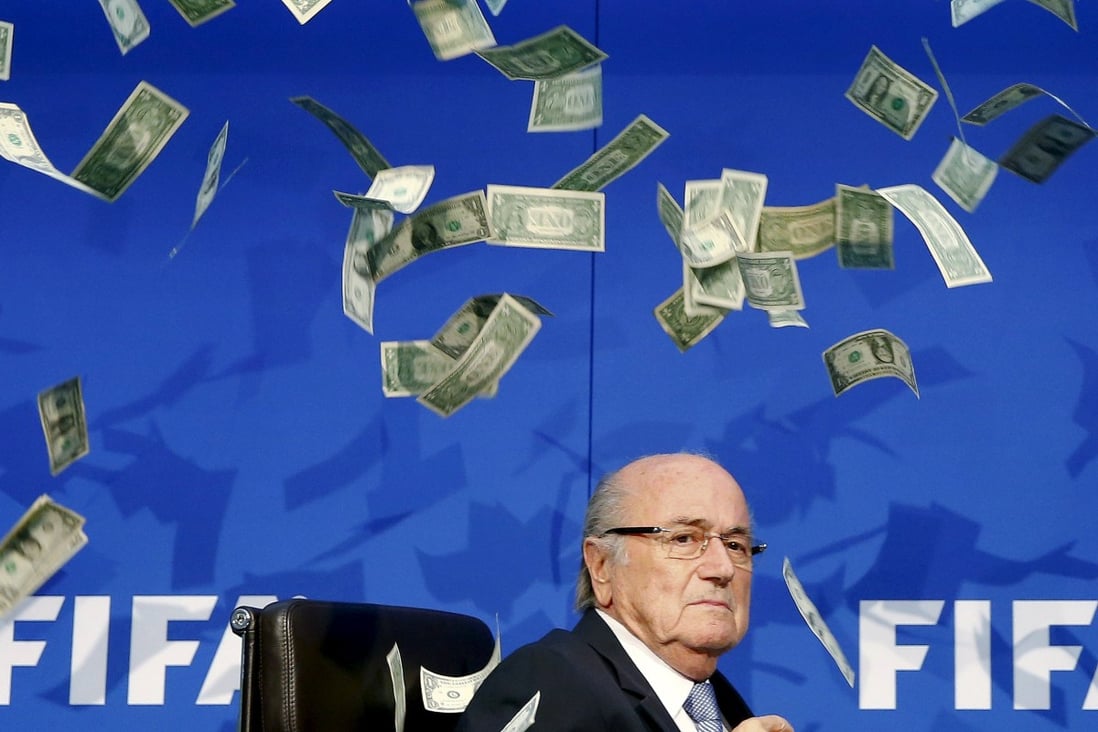 Comedian Simon Brodkin (unseen) throws fake dollars at Blatter. Photo: Reuters