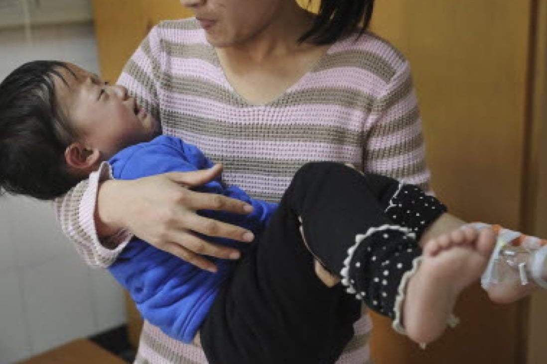 A mother in Hebei, Anhui province, holds her son, who is being treated for hepatitis C -- for which there is no vaccine yet. Photo: AP