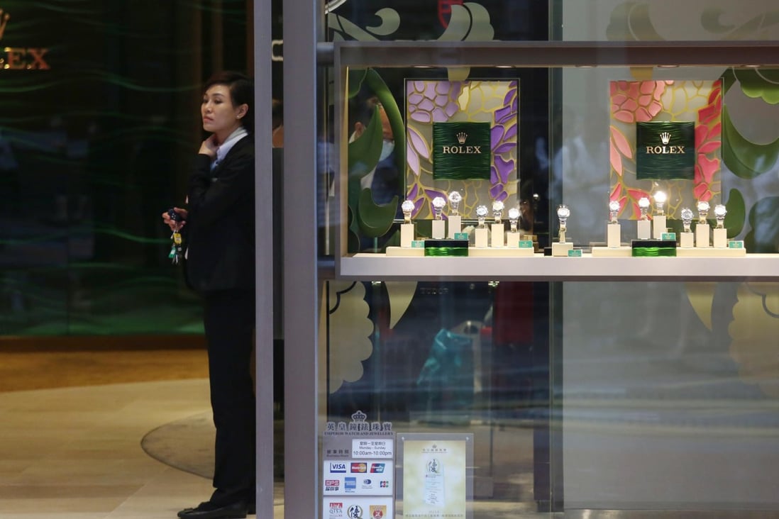 A staff member stands at the entrance to a near-empty store selling prestigious Rolex watches in Causeway Bay. Photo: Nora Tam