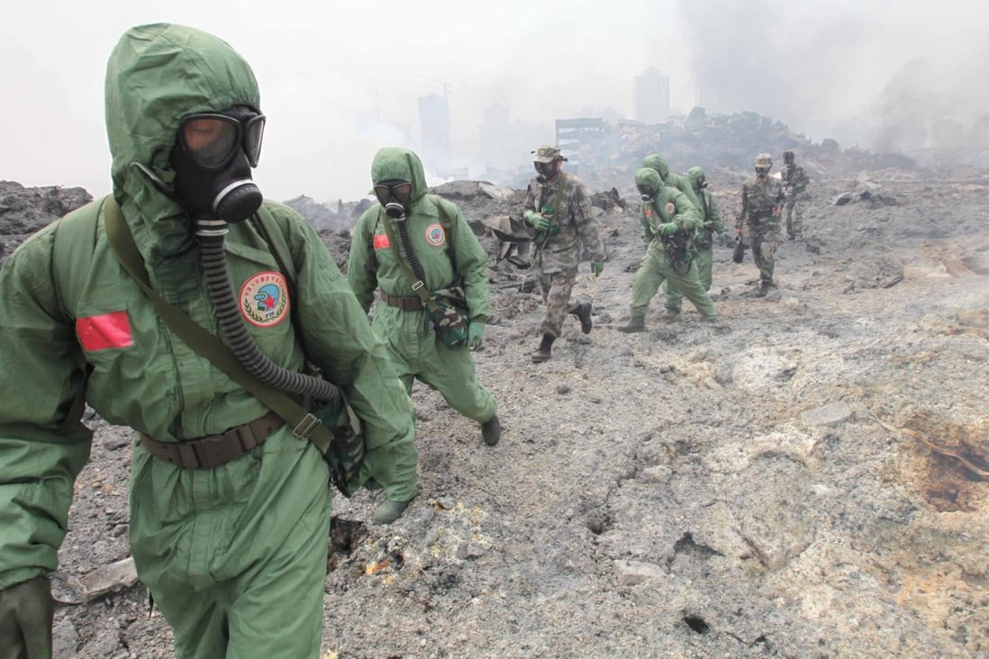 Troops in biochemical safety gear search the blast site yesterday.Photo: Xinhua