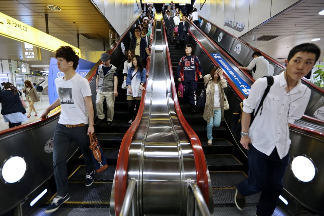 Japanese commuters ride escalators in a Sapporo train station. Photo: Bloomberg