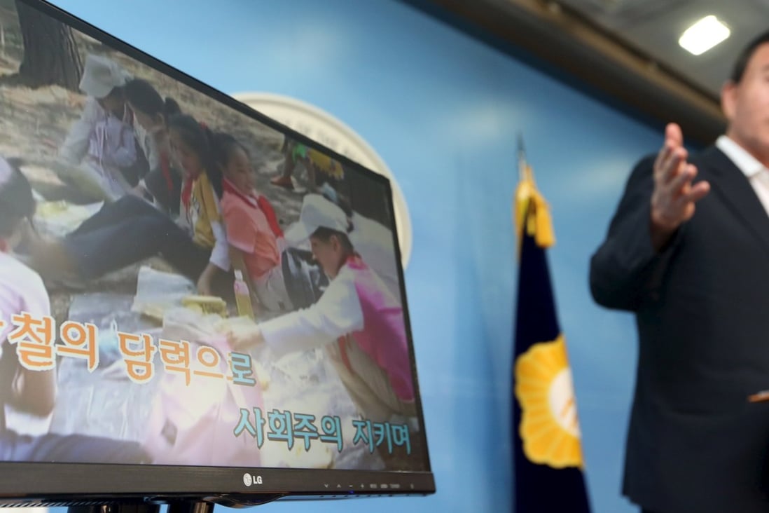 A politician demonstrates a karaoke machine in which a song and footage from North Korea has been installed in Seoul. Photo: Reuters
