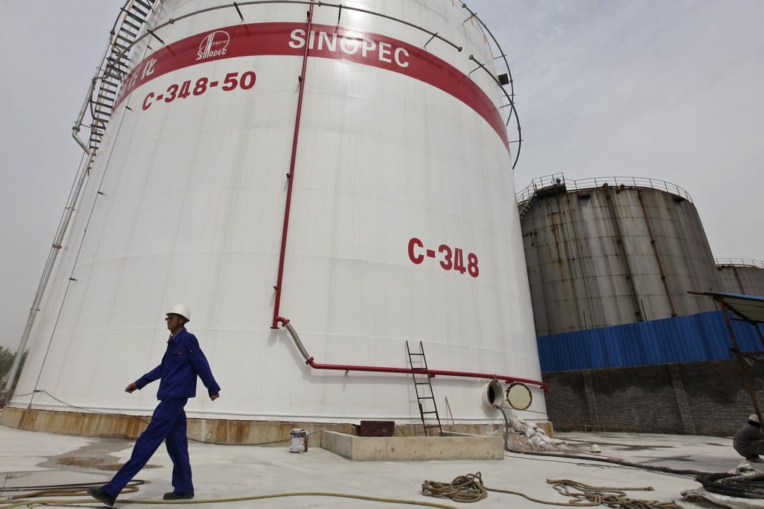 An employee walks past oil tanks at a Sinopec refinery in Wuhan, Hubei province. China aims to expand Communist Party leadership and governance in state firms at the same time. Photo: Reuters