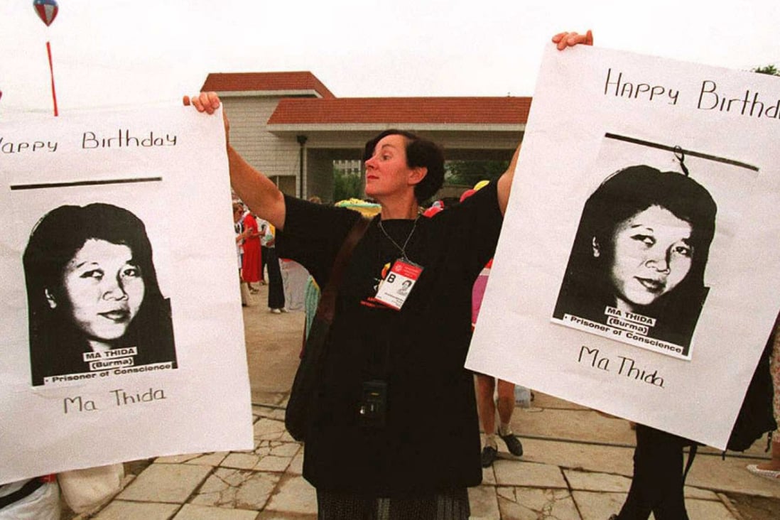 An Amnesty International activist holds photos of then-imprisoned Ma Thida at a birthday party organised in her honour by the NGO at the Fourth World Conference on Women, in Beijing, in 1995. Photos: Khin Mg Win; AFP