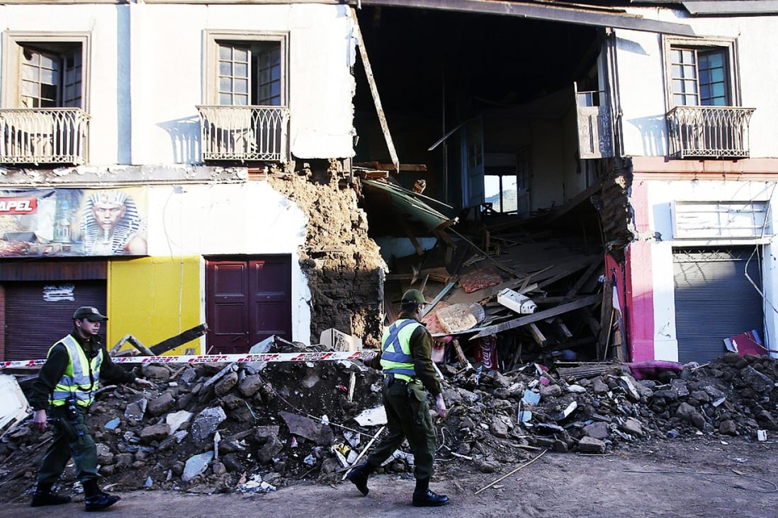 Policemen seal off a damaged building following an 8.3-earthquake in Illapel, Chile. Photo: TNS