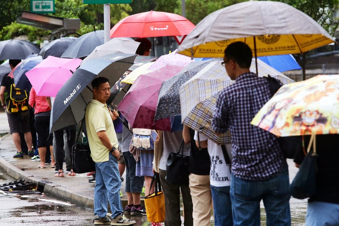 People queue for public transport in Ma On Shan during today's rainstorm. Photos: Sam Tsang/SCMP