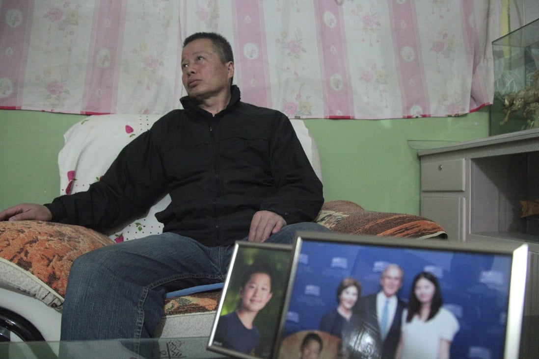 In this photo taken in 2015, Gao Zhisheng sits in a cave home in Shaanxi province. In the foreground are photos of his son and one of his daughter with former US President George Bush. Photo: AP