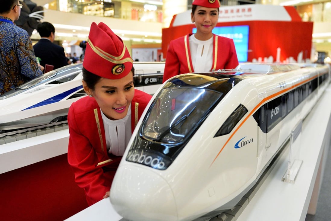 Indonesian models view scale models of Chinese-made bullet trains on exhibition at a shopping mall in Jakarta. Photo: AFP