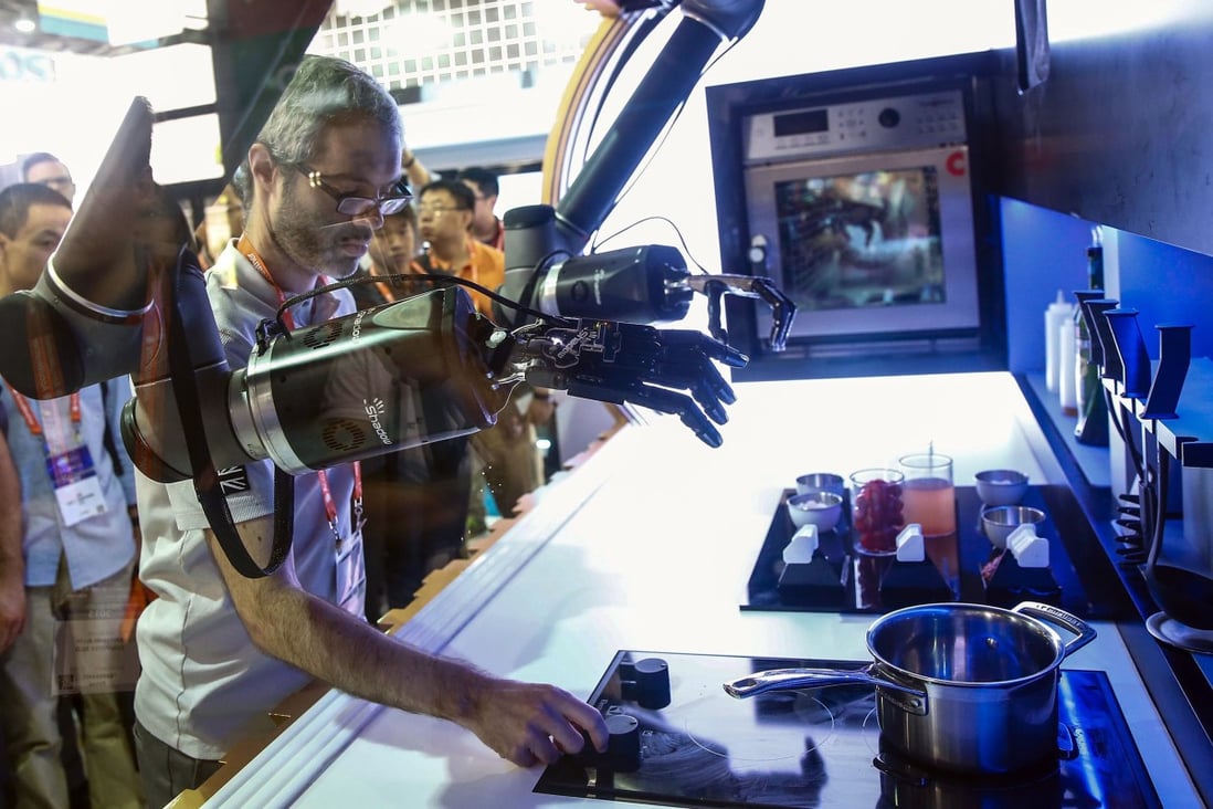An exhibitor demonstrates a robot to visitors during the first Consumer Electronics Show (CES) in Asia in Shanghai on May 25. China is focusing more on domestic consumption, high technology and innovation as it looks to wean itself off exports and state-led investment growth. Photo: AFP