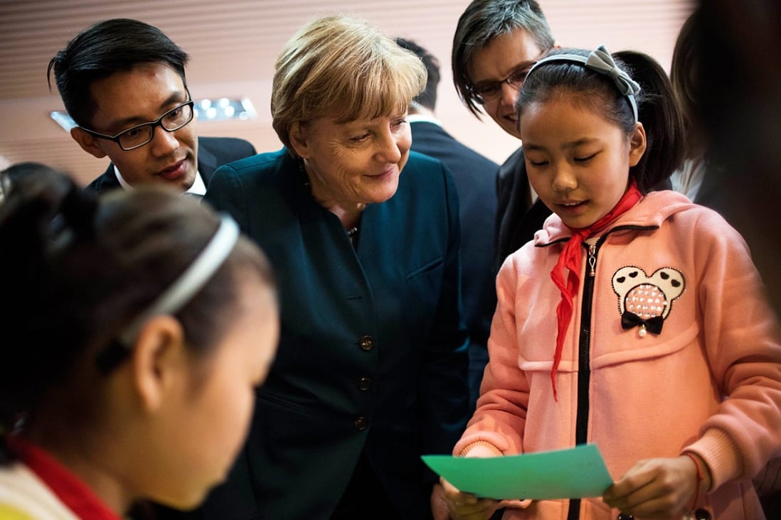 German Chancellor Angela Merkel talks to a student of the Jinputao school in Xinnacun village in the Baohe district of Hefei, China. Photo: AFP