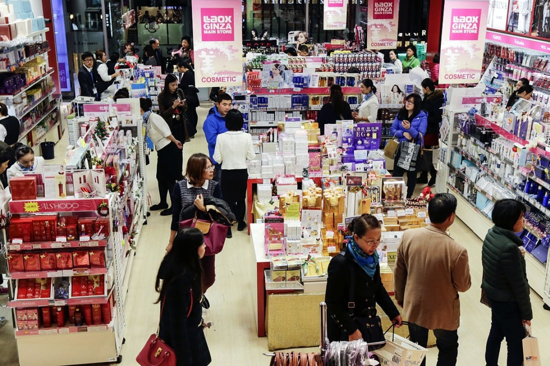 Chinese tourists shopping on the floor of a cosmetics department at a discount shop during their bulk buying. Photo: EPA