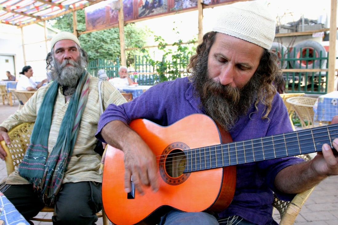 Amir Dromi (on right playing guitar) and Oran Benron are Jewish farmers from Israel who are searching the Taklamakan Desert for evidence that one of the Lost Tribes of Israel lived there. They are pictured here in Kashgar as they prepare to go into the desert. Photo: Doug Nairne