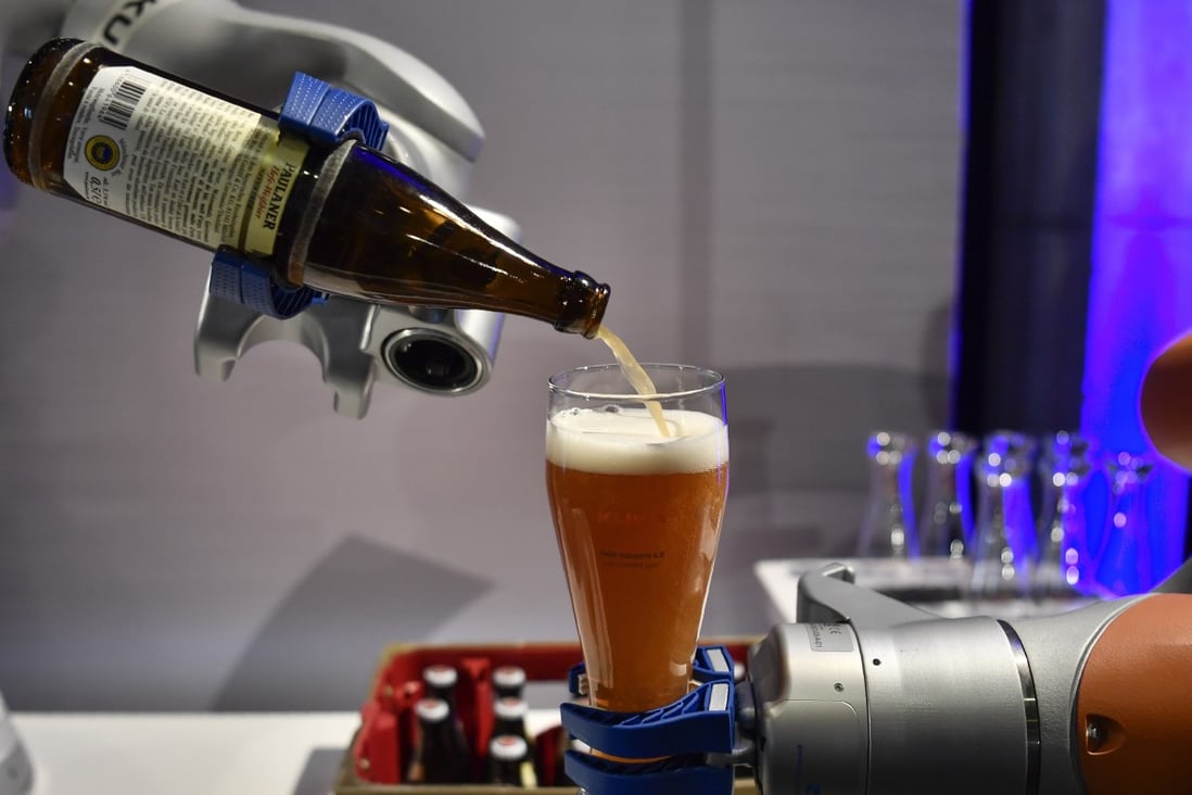 Robotic arms made by Kuka pours a beer (Source: AFP)