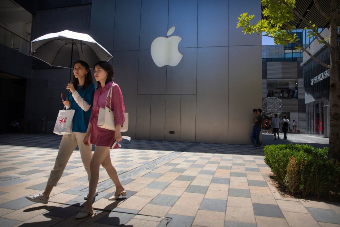People walk past an Apple store at a shopping mall in Beijing in 2019. (Picture: AP)