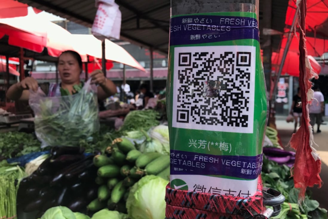 Mobile payments are so ubiquitous in China that even outdoor markets make sure their QR codes are prominently displayed for easy payment. (Picture: Simon Song/SCMP)