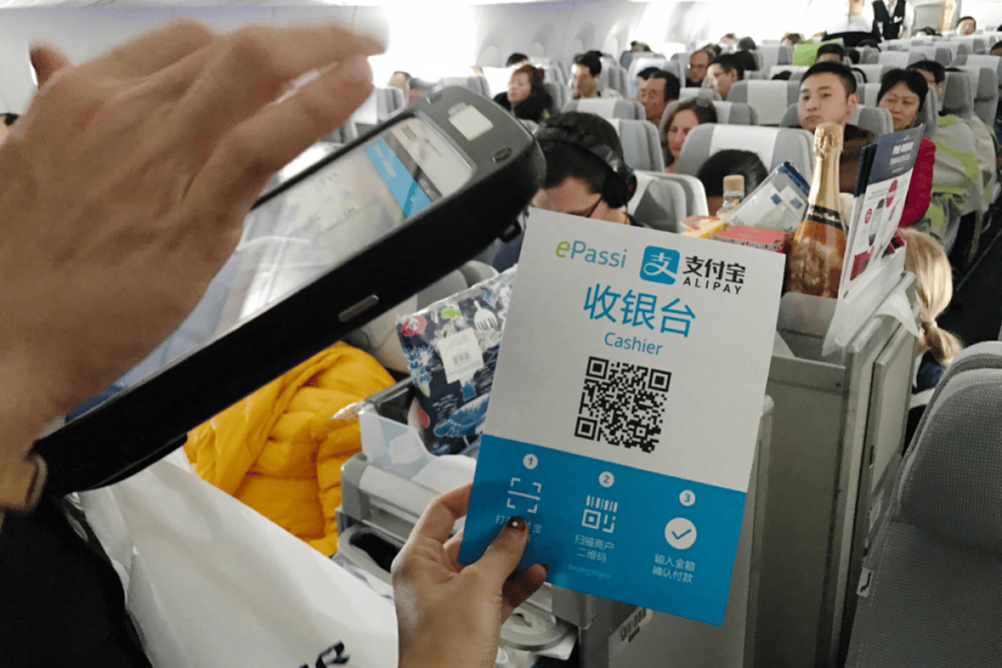 A customer scanning an Alipay payment code held by a flight attendant on a plane bound for Helsinki from Beijing. (Picture: Zhang Xuan/Xinhua)