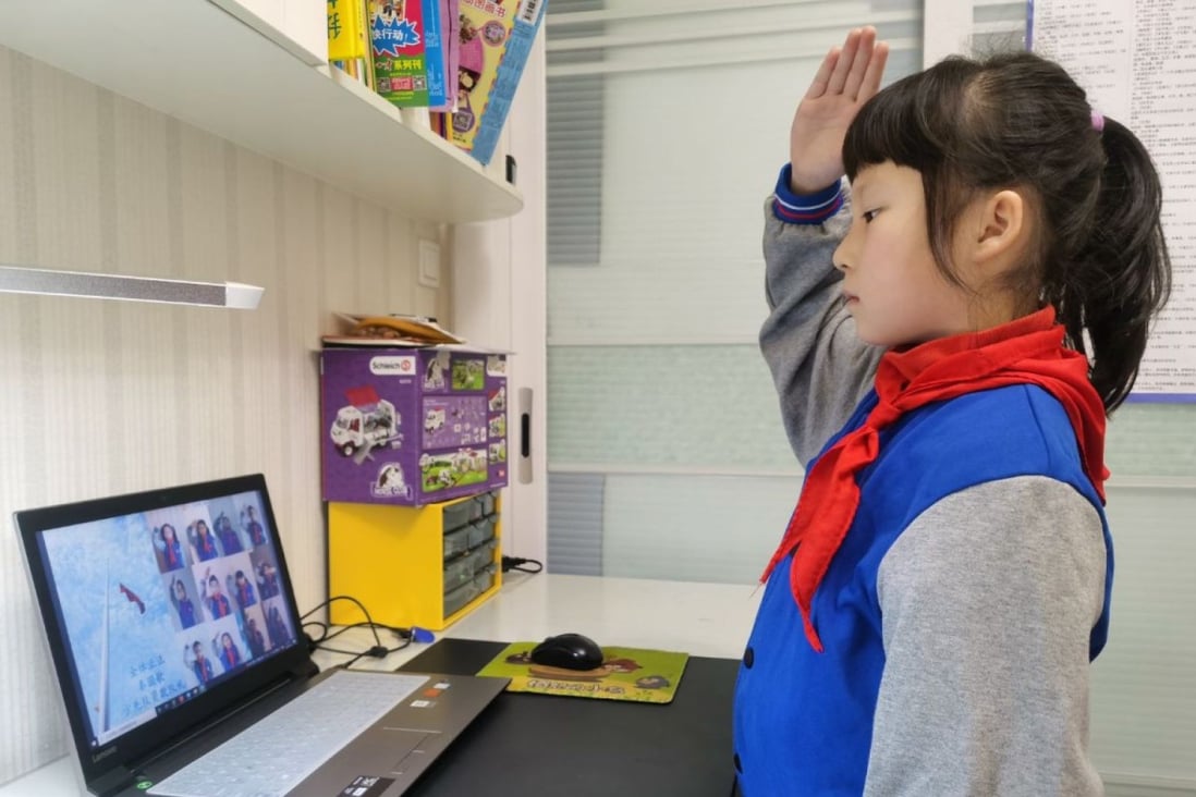 A primary school student salutes to the national flag while attending an online flag-raising ceremony at her home in Wuhan, the epicenter of the coronavirus outbreak. (Picture: China News Service)
