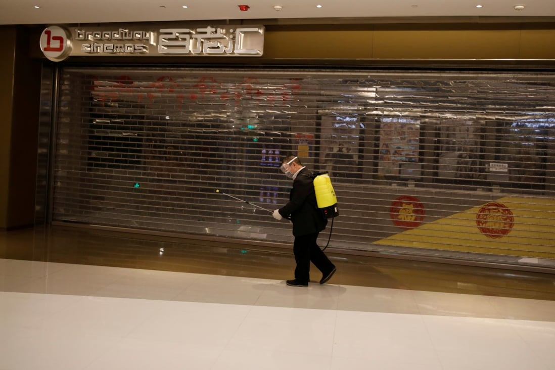 A shopping mall worker carrying sanitizing equipment outside a closed cinema in Beijing on February 3. (Picture: Carlos Garcia Rawlins/Reuters)