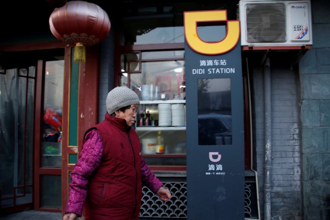 A woman walks past a Didi Chuxing sign in Beijing on January 2, 2019. (Picture: Jason Lee/Reuters)