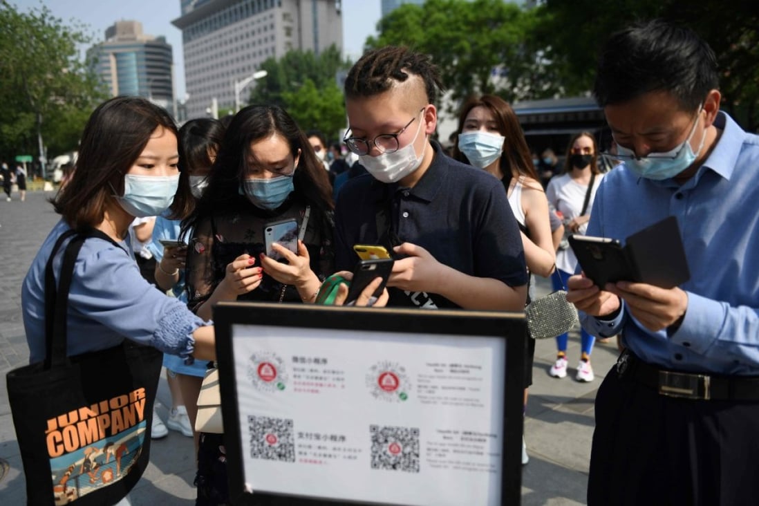 People use QR codes required to prove their health and travel status before being allowed to enter a shopping mall in Beijing on May 2, the second day of a five-day national holiday. (Picture: AFP)