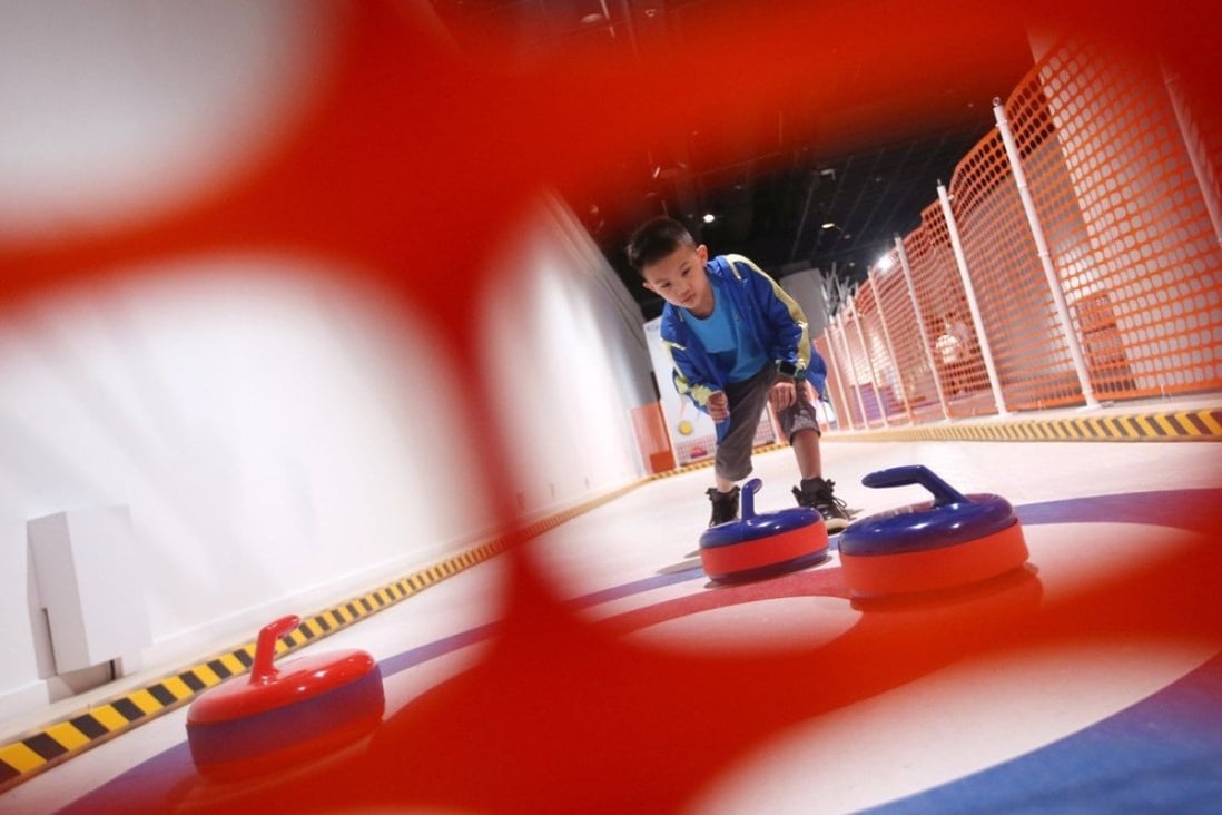 Raphael Siauw tries his hand at curling at the Winter Games exhibition at the Hong Kong Science Museum in 2019. Photo: David Wong