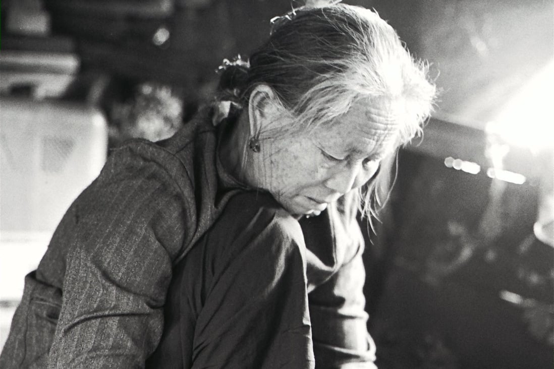An elderly woman assembles plastic flowers at the Yau Ma Tei Typhoon Shelter in 1970. Photo: SCMP