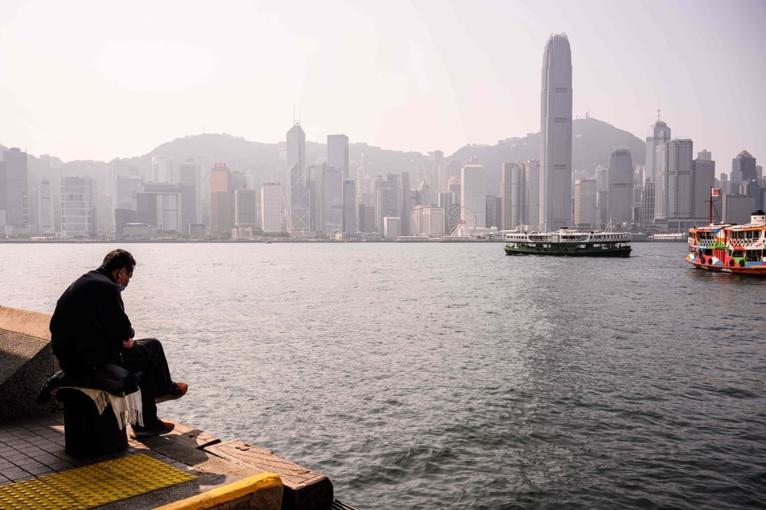 A man sits by the Victoria Harbour in Hong Kong on January 27. The travel restrictions and social distancing measures have had an impact on the economy but they are necessary for now. Photo: AFP 