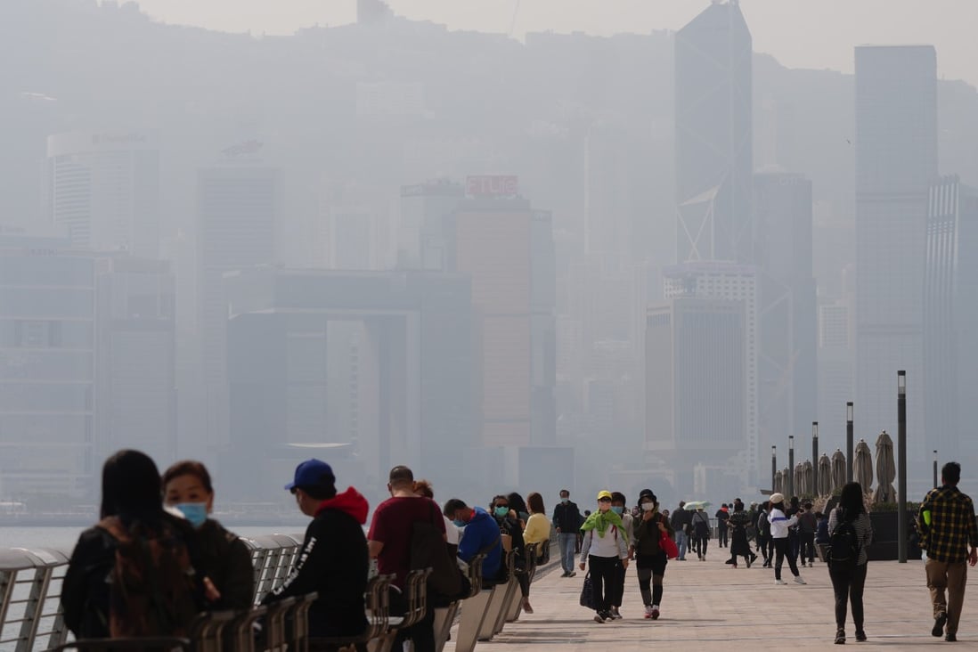 People stroll down the Tsim Sha Tsui waterfront promenade as Hong Kong Island is shrouded in smog on January 17. Photo: Sam Tsang